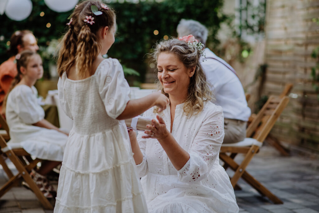 Mädchen übergibt Braut Geschenk zur Hochzeit