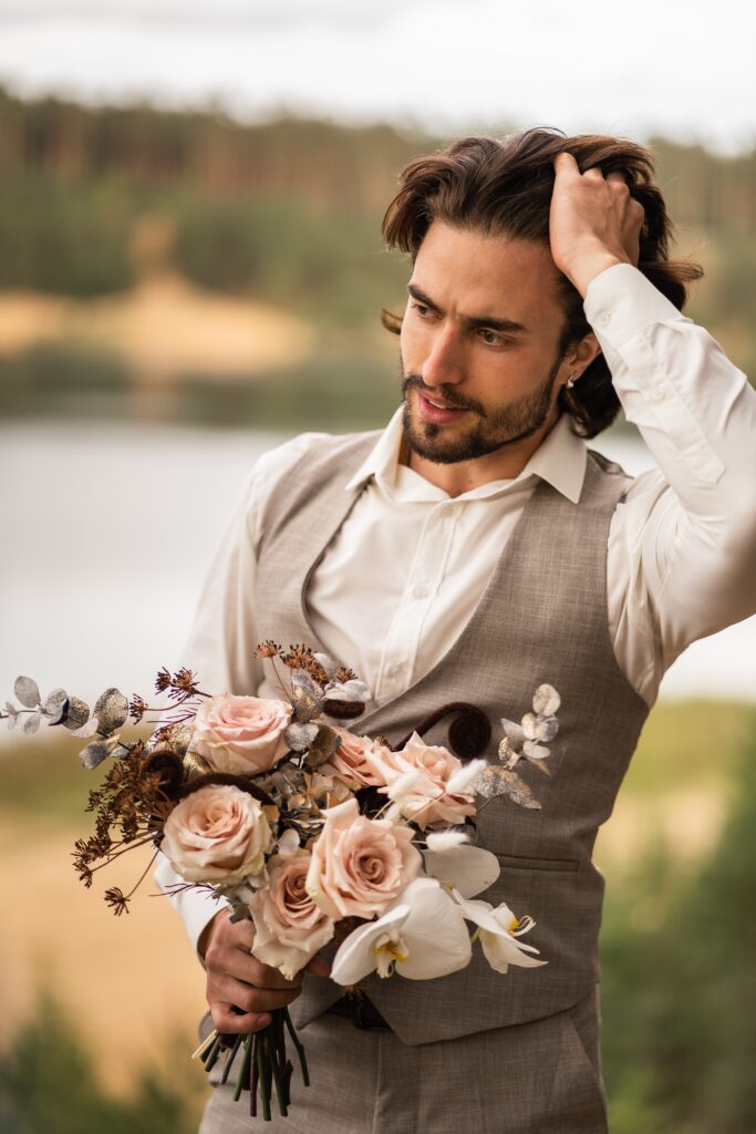 Bräutigam mit Brautstrauß aus Rosen und Orchideen