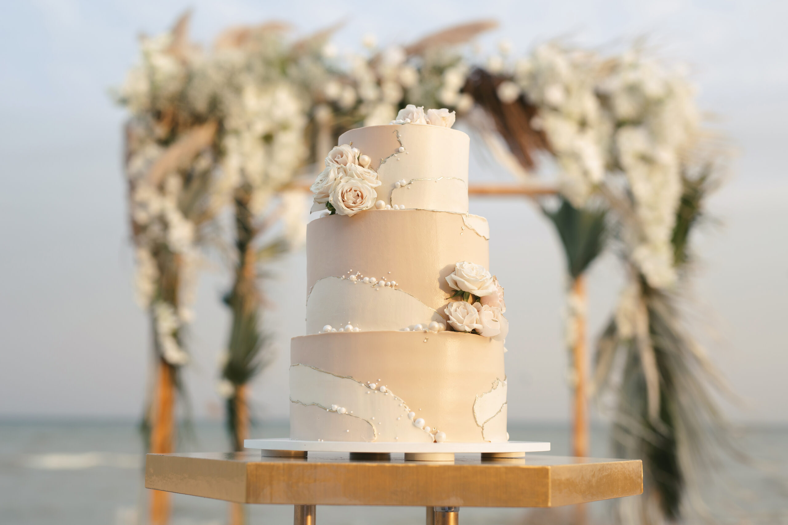 Klassische Hochzeitstorte in beige mit Rosen bei Boho-Hochzeit am Strand