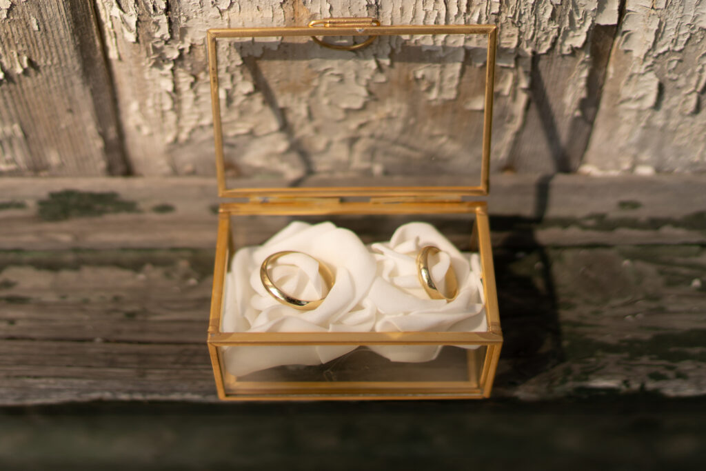 Personalisierte goldene Ringbox mit weißen Rosenblättern