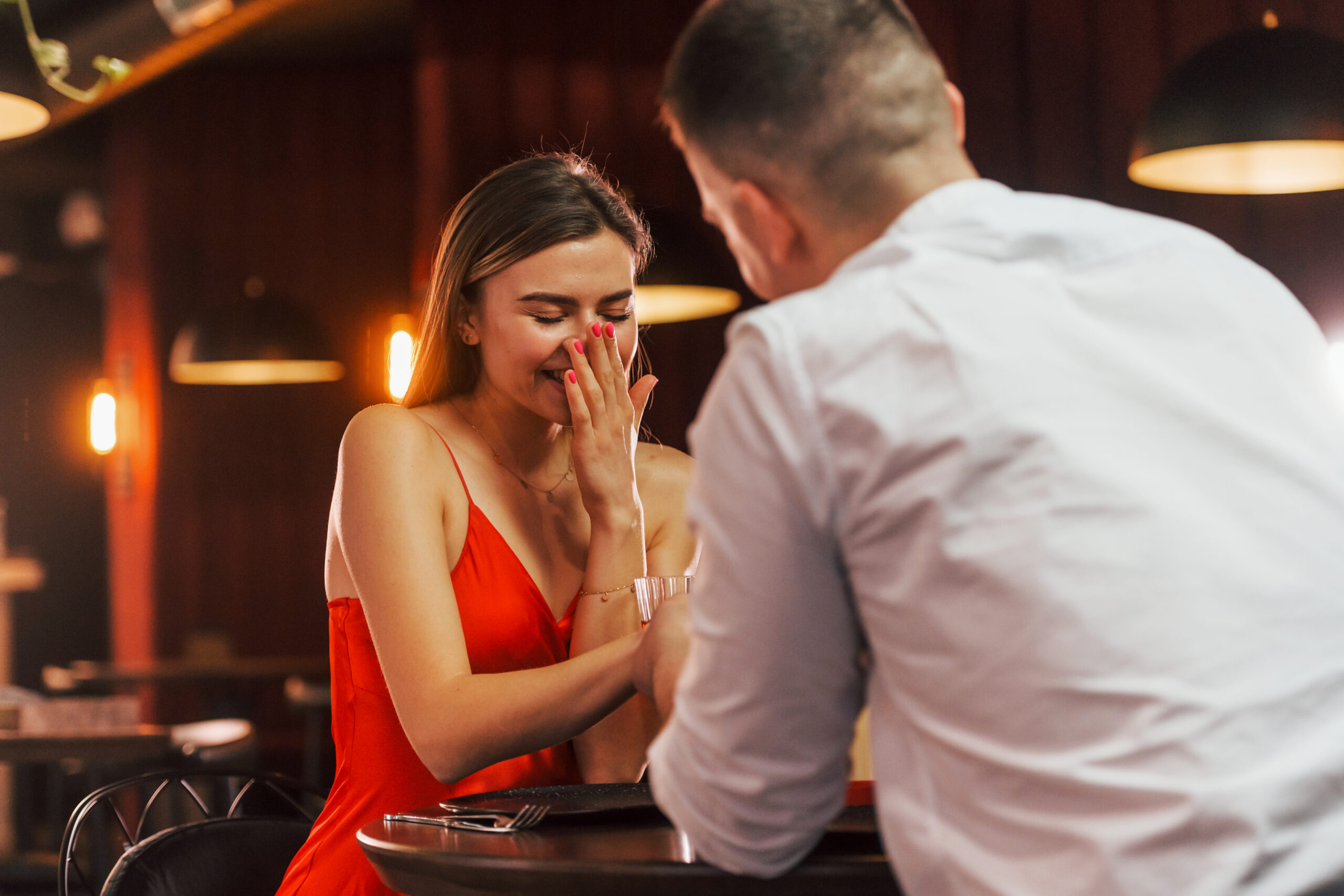 Mann macht seiner Freundin einen Heiratsantrag an Silvester im Restaurant