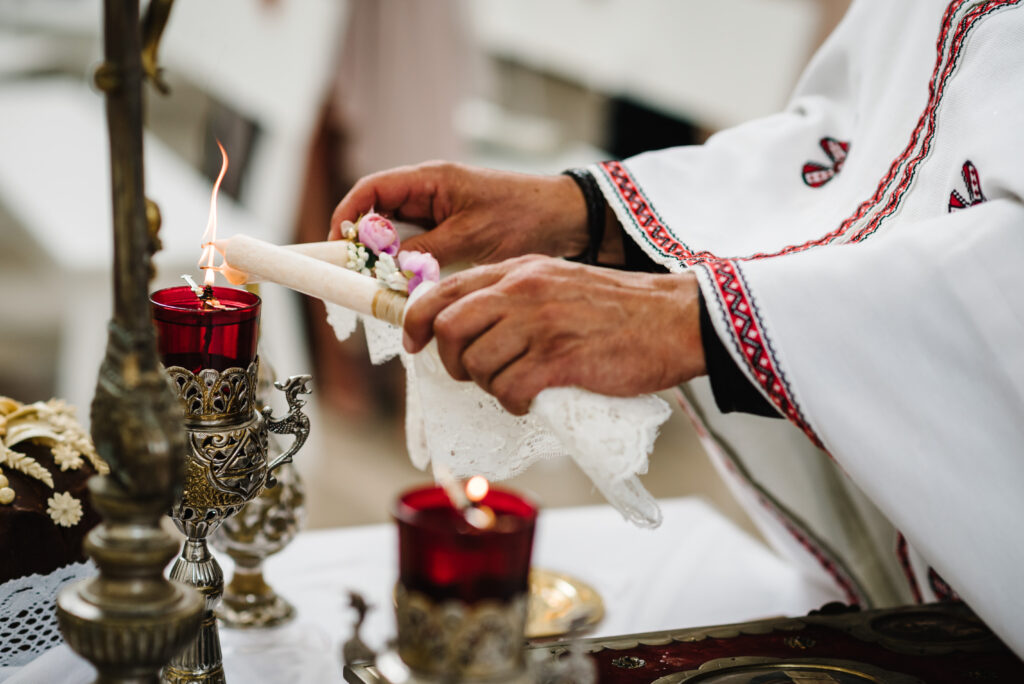 Hochzeitskerzen werden angezündet Priester