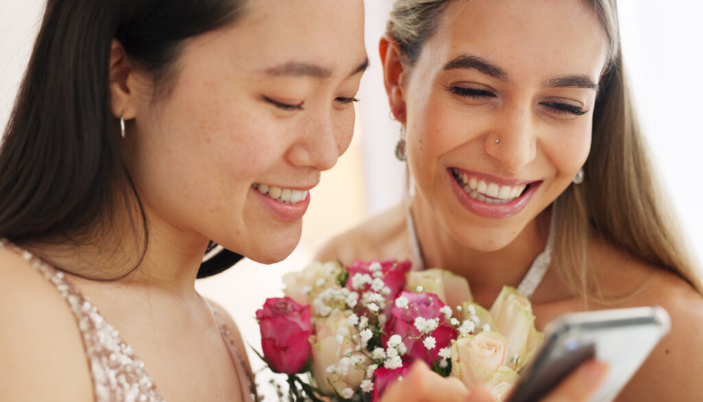 Braut und Brautjungfer cheken Instagramaccount der Hochzeitsfeier